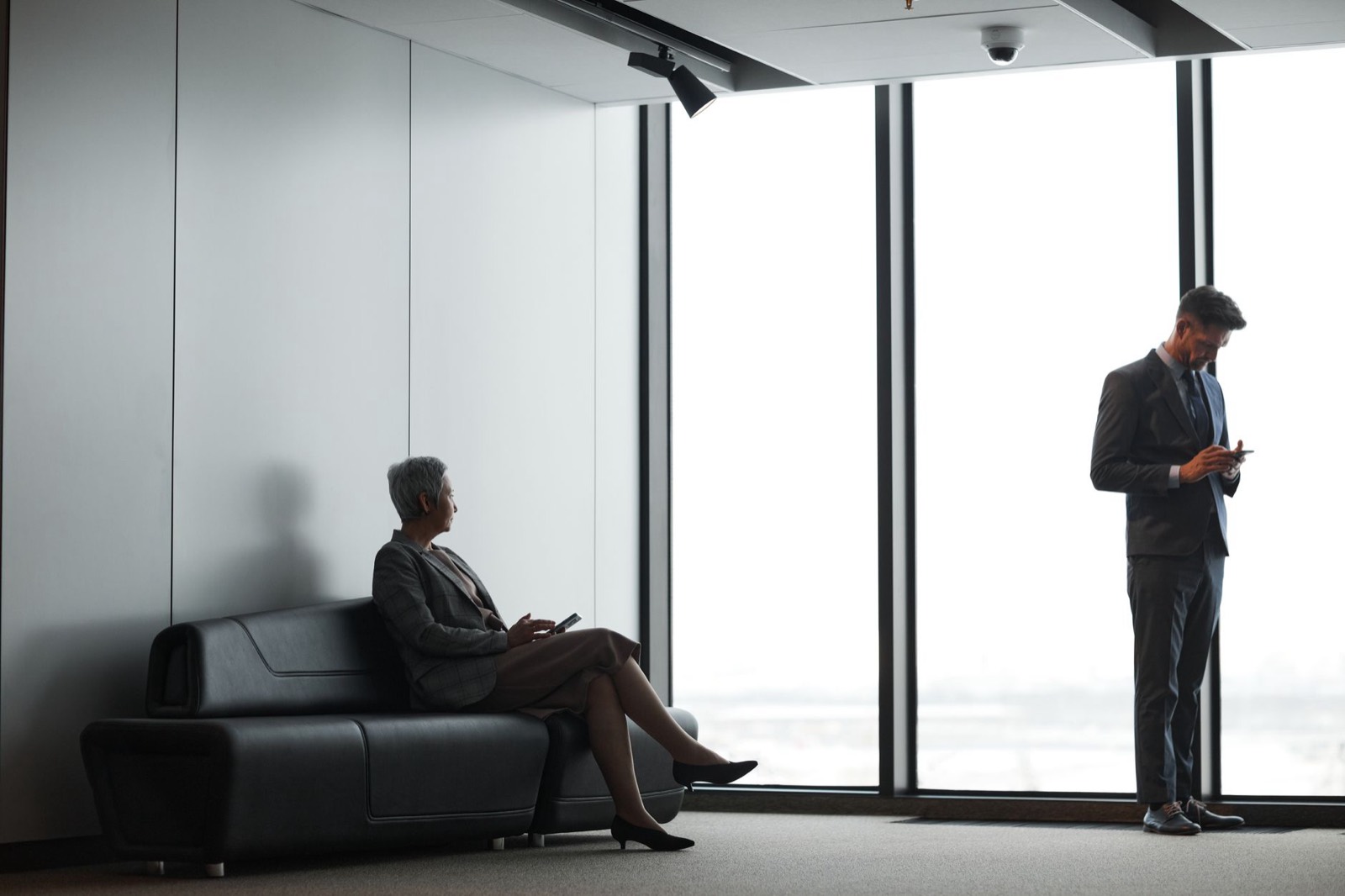 Deux dirigeants dans le hall vitré d'un immeuble de bureaux contemporain